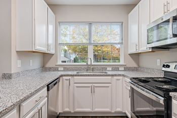 A kitchen with granite counter tops and a window